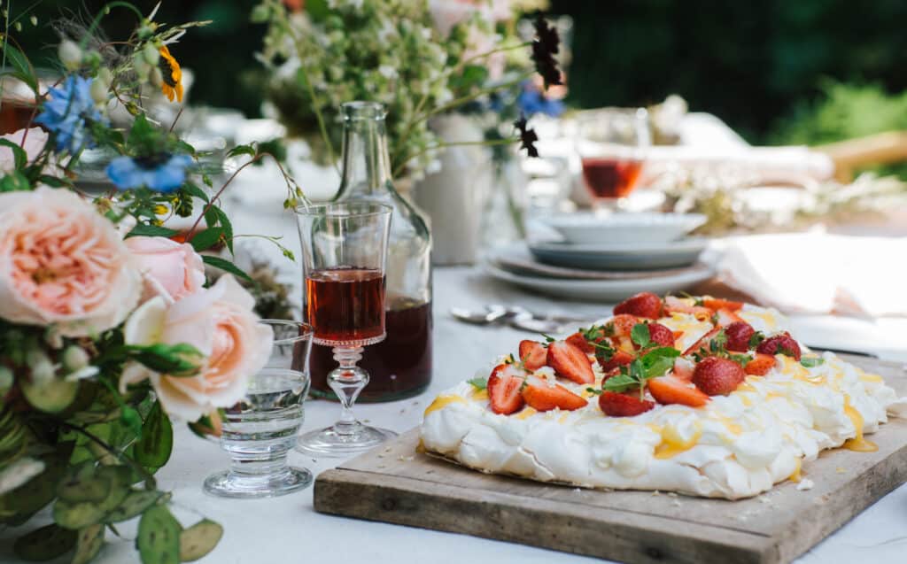 A decorated table with strawberry cake outdoors